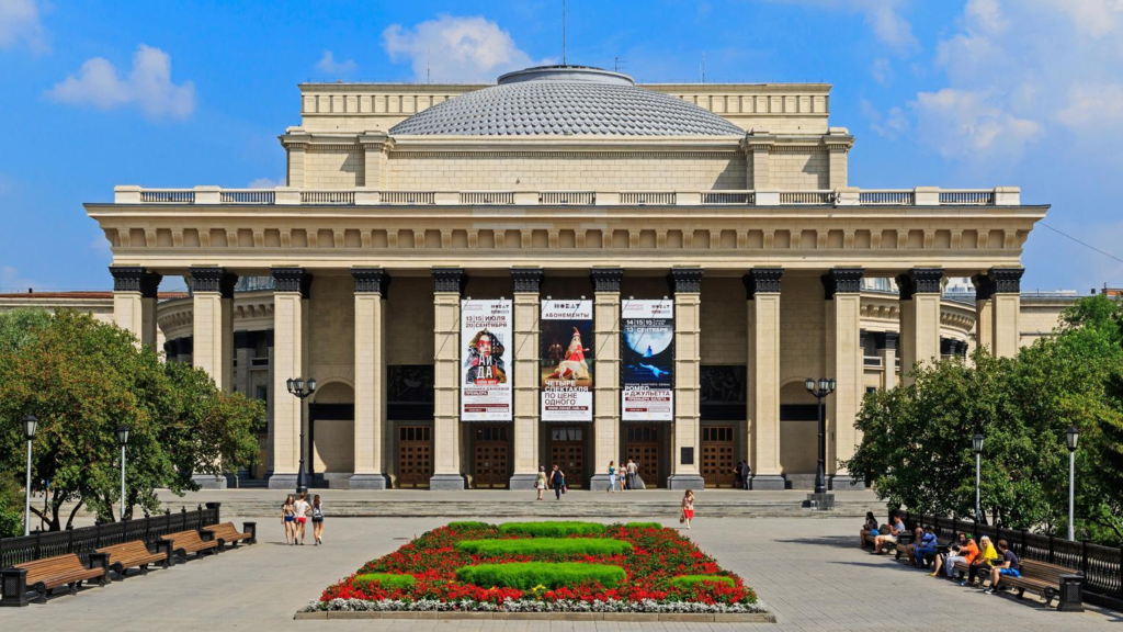 Visitors exploring the Novosibirsk State Academic Opera and Ballet Theatre in Russia, a cultural landmark.