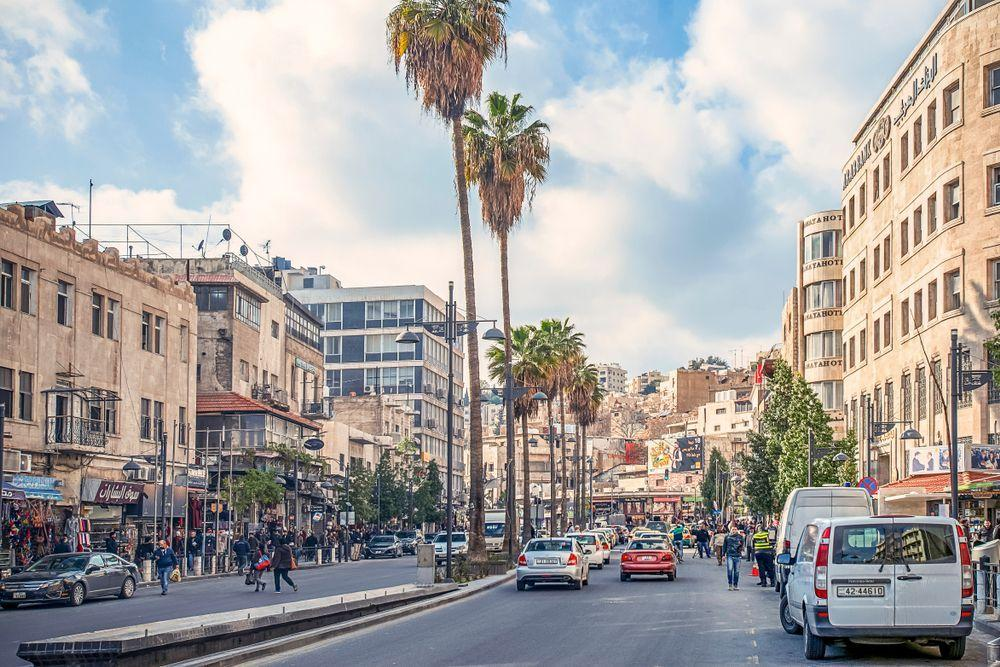 Street scene in Amman, Jordan showing shops, traffic, and everyday urban life