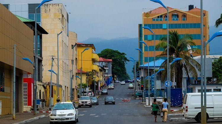 People walking through streets and markets in Malabo with shops, cafés, and local vendors