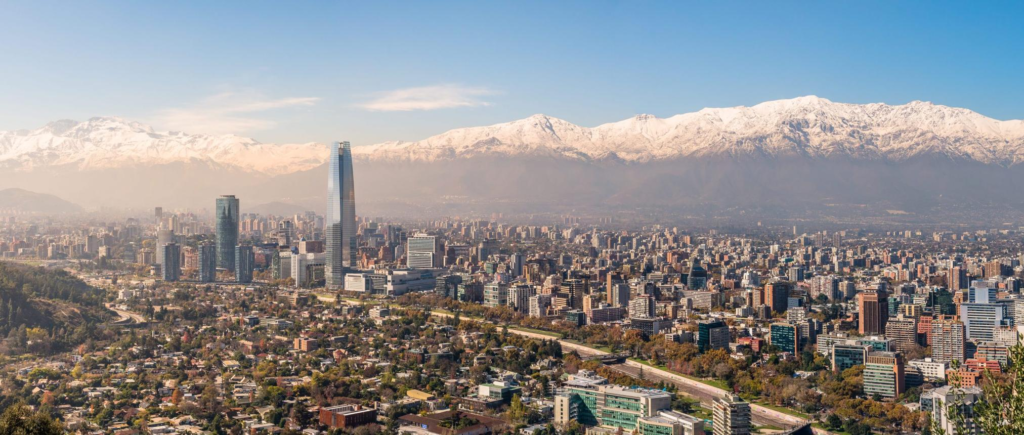 A panoramic view of Santiago with the Andes Mountains rising behind the city.