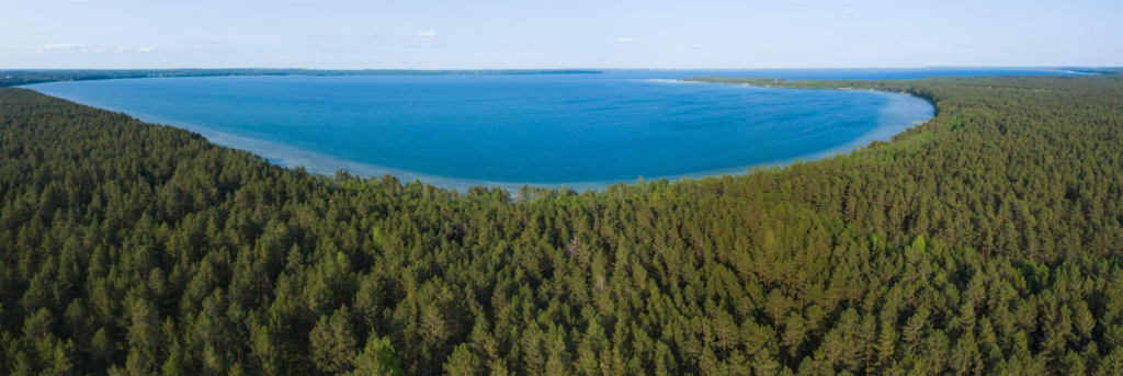 A peaceful lake surrounded by forests and rolling hills in Braslav Lakes National Park.