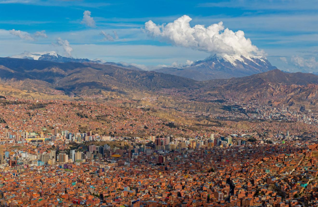 A panoramic view of La Paz spreading across a mountain valley with Illimani rising in the background.
