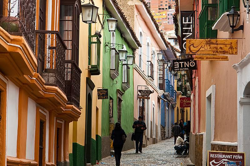Visitors walking along the colorful colonial buildings of Calle Jaén in La Paz.