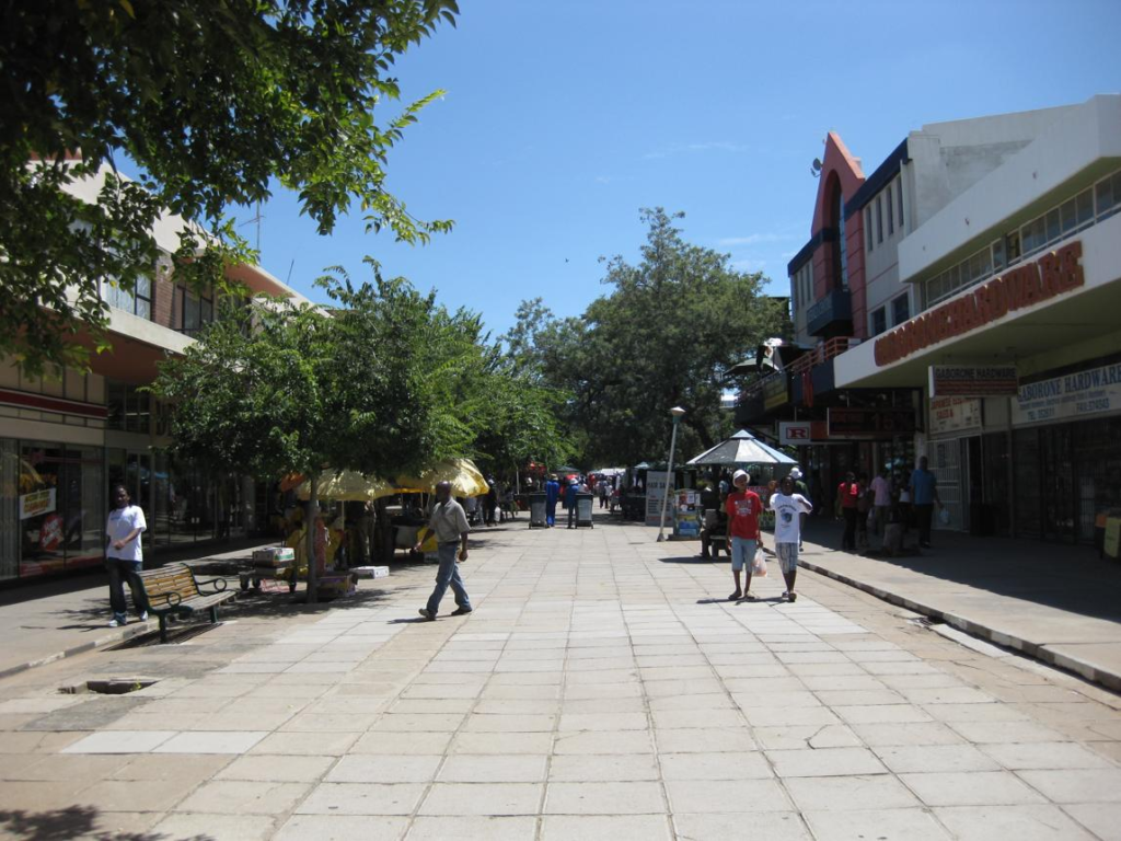 People walking through Gaborone's Main Mall lined with shops, cafés, and public spaces.