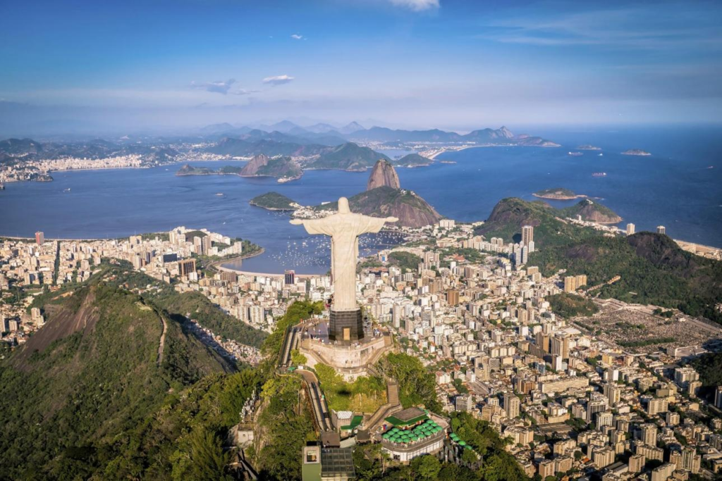 An aerial view of Rio de Janeiro with Sugarloaf Mountain, Guanabara Bay, and the surrounding coastline.