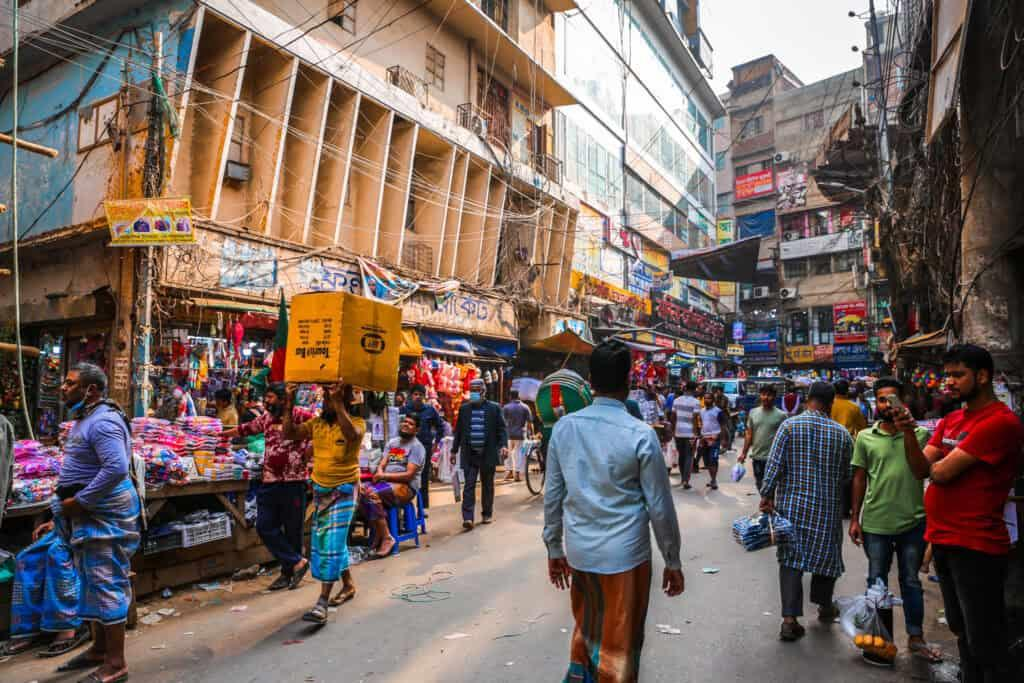 People walking through a busy market street in Old Dhaka.