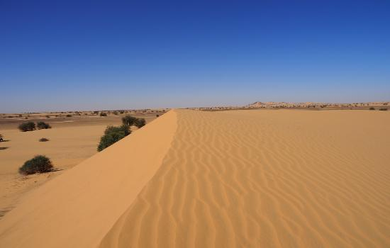 Sand dunes and rocky desert scenery in the Nubian Desert, Sudan.